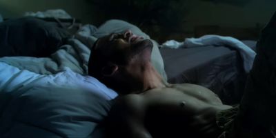 a man laying in bed with his eyes closed