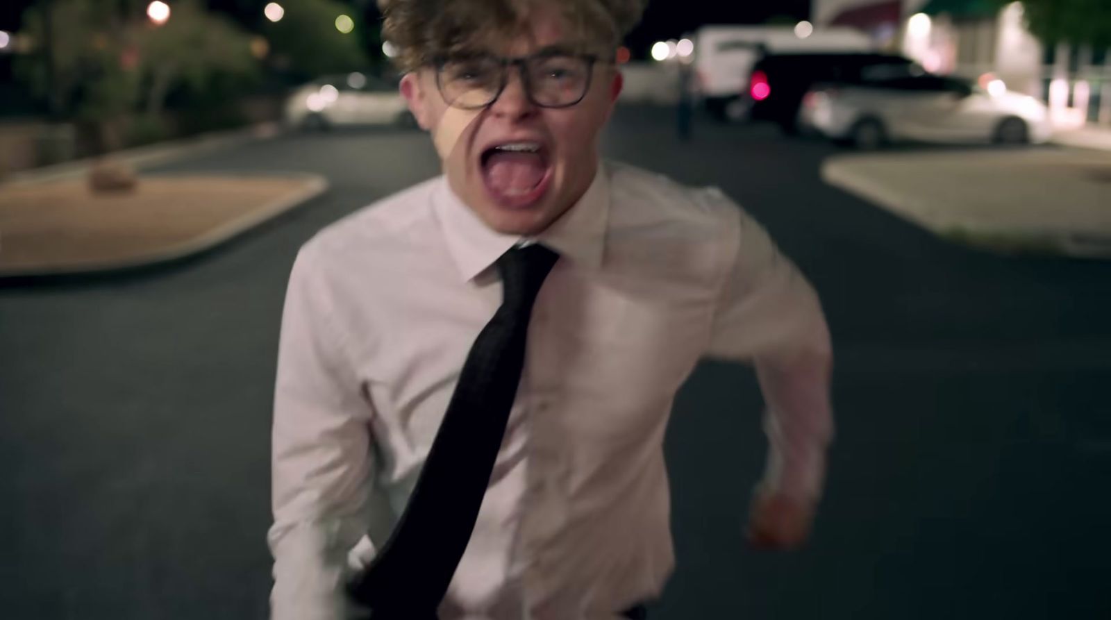 a man with glasses and a tie making a funny face