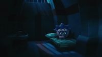 a stuffed animal sitting on top of a bed in a dark room