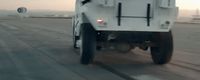 a white dump truck driving down a street