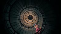 a person standing in the middle of a spiral staircase