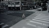 a man riding a skateboard down a street next to tall buildings