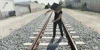 a person standing on a train track with a box on their head