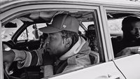 a black and white photo of two men in a car