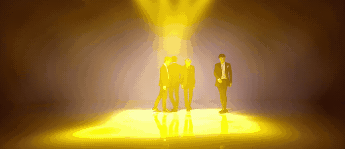 two men standing in front of a yellow light