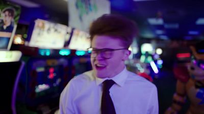 a man wearing glasses and a tie standing in a room