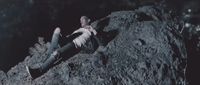 a man laying on top of a large rock