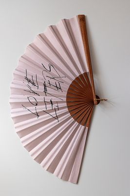 a fan with writing on it hanging on a wall