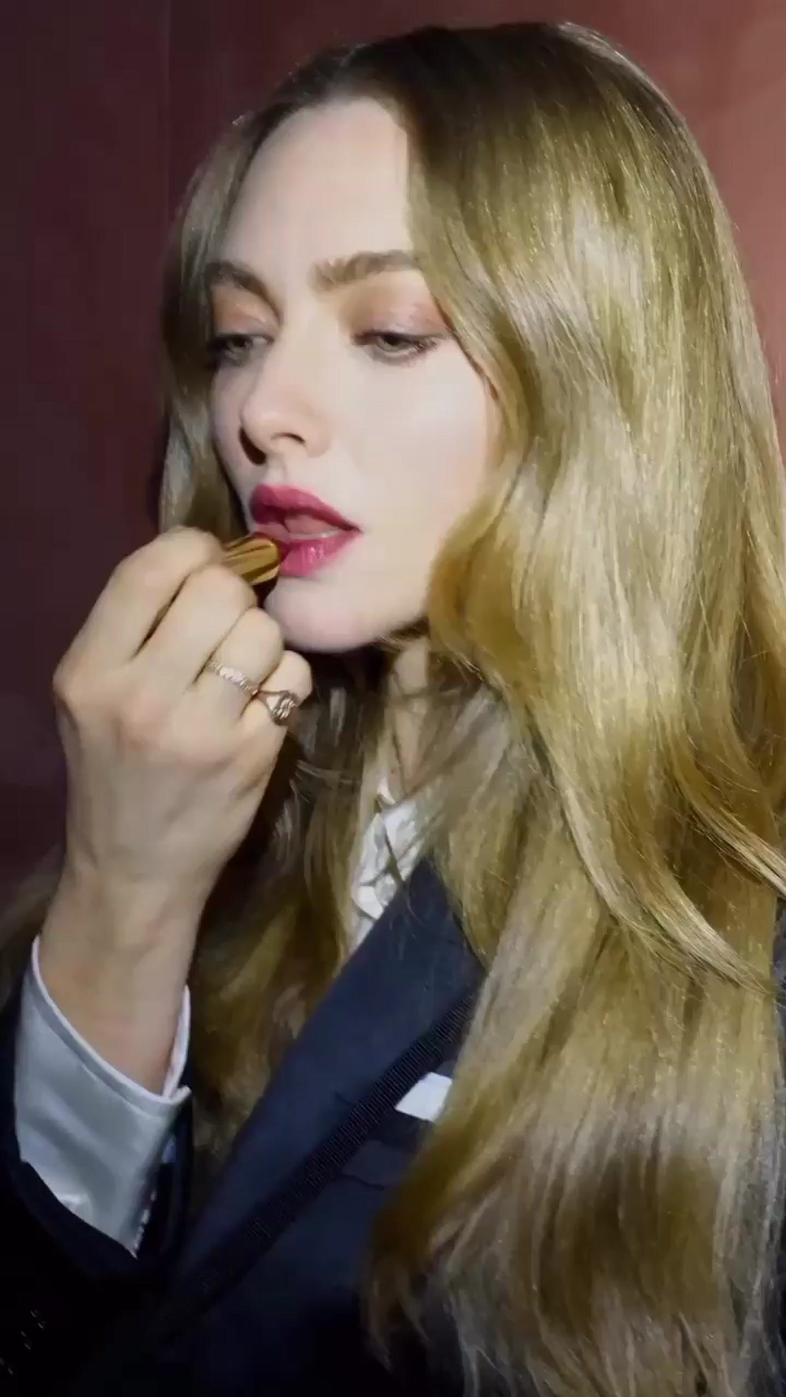 a woman with long blonde hair brushing her teeth