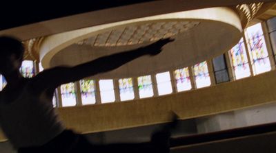 a man holding a frisbee in front of stained glass windows