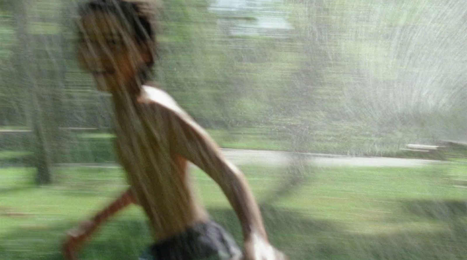 a boy running in the rain with a frisbee