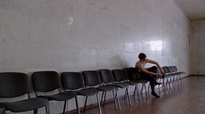 a man sitting in a row of empty chairs