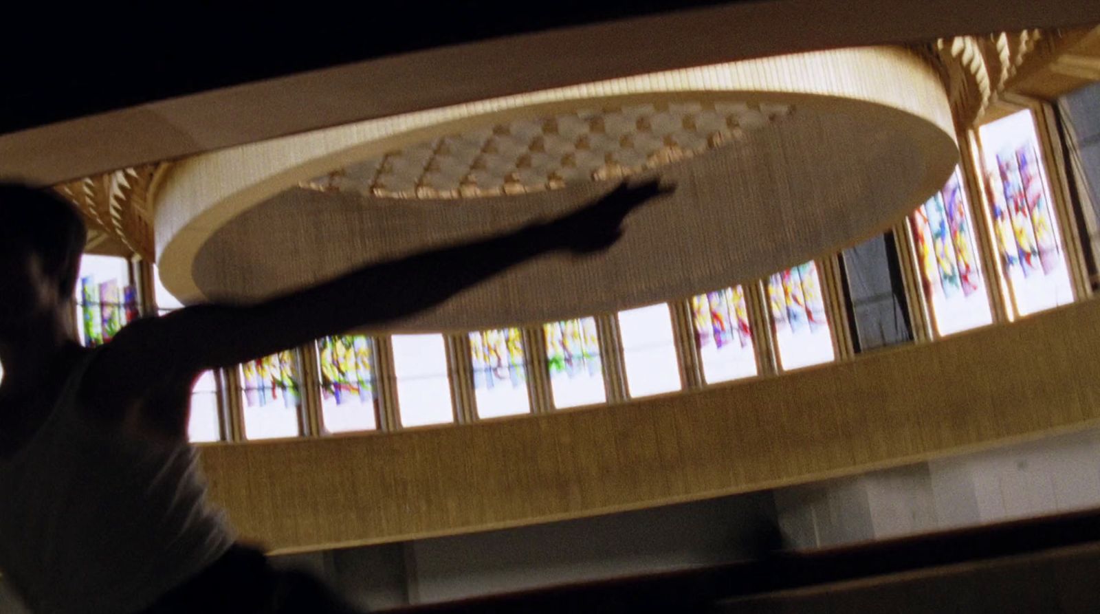 a man holding a frisbee in front of stained glass windows