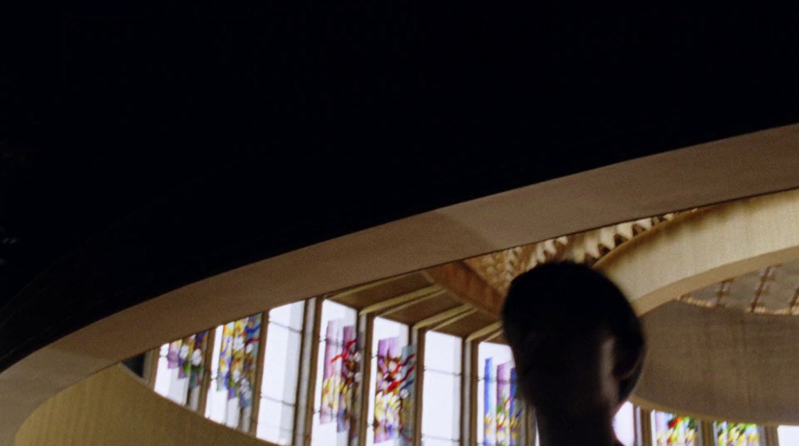 a man standing in front of a stained glass window