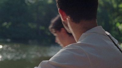 a man sitting on a bench next to a lake