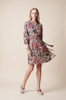 a woman in a floral dress poses for a picture
