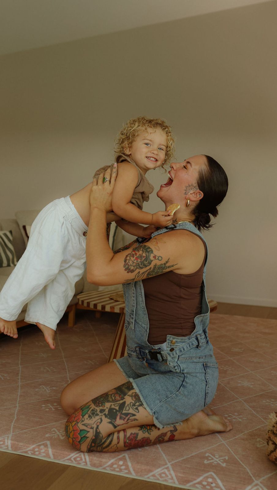 a woman sitting on the floor holding a child