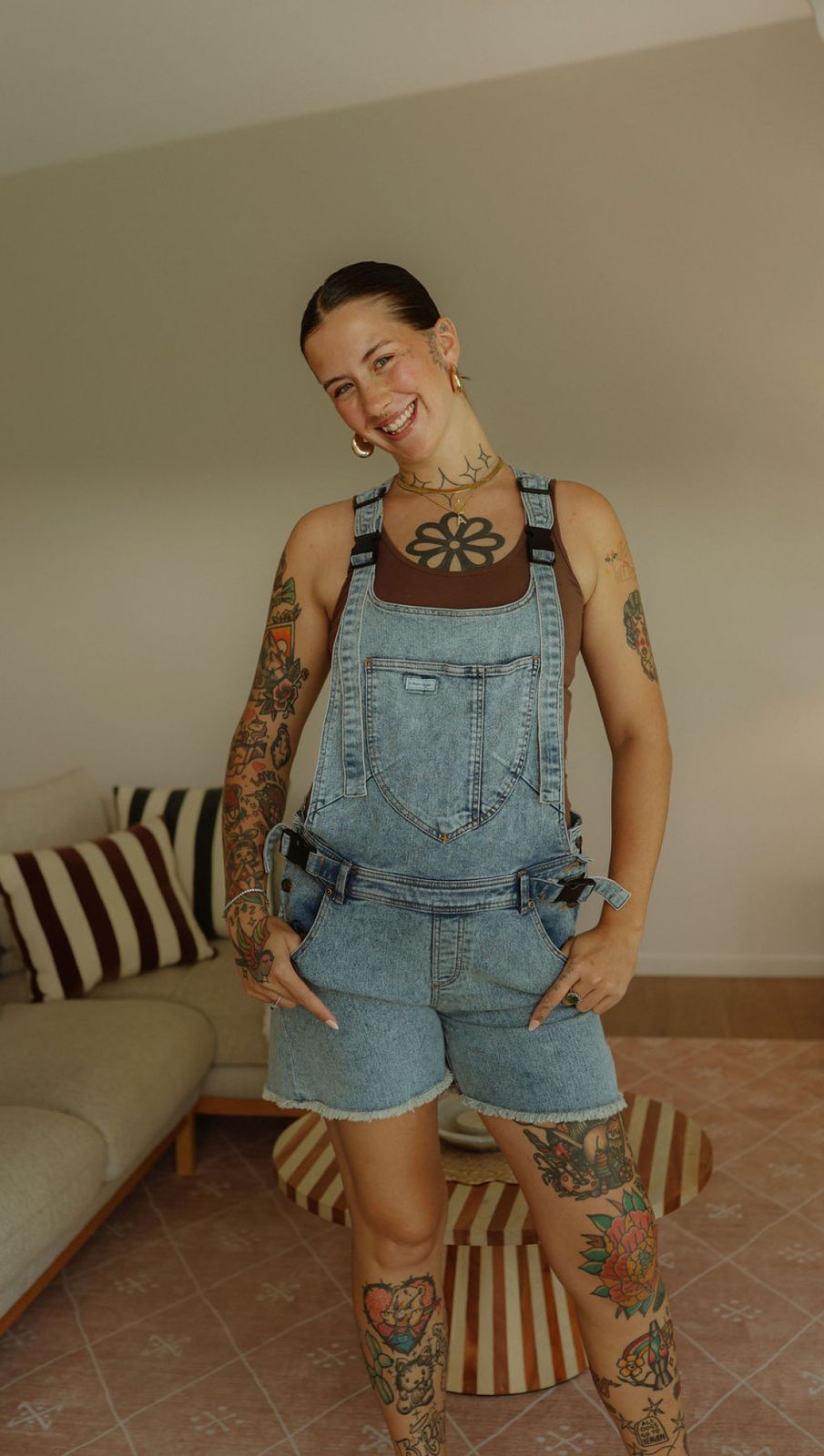 a woman with tattoos standing in a living room