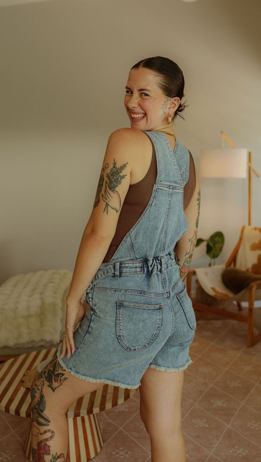 a woman with a tattoo on her arm standing in a room