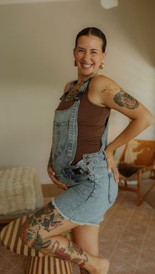 a woman with a tattoo on her arm posing for a picture