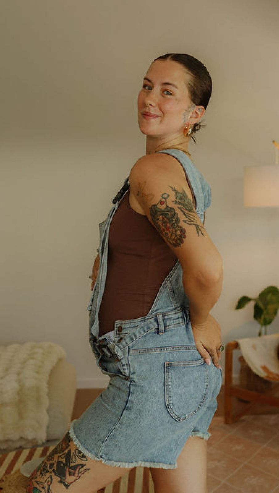 a woman with a tattoo on her arm standing in a living room