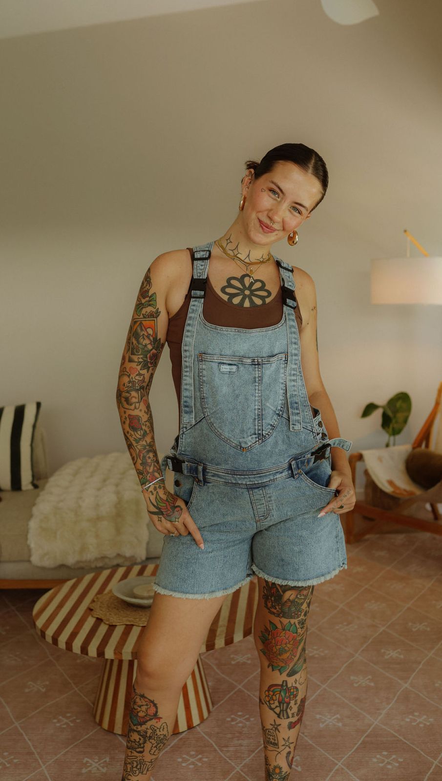 a woman with tattoos standing in a room