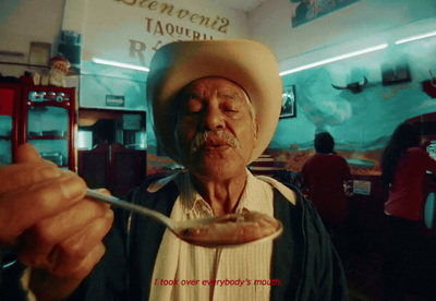 a man in a cowboy hat holding a spoon