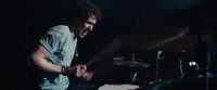 a man playing drums in a dark room