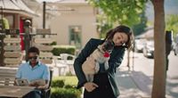 a woman holding a pug dog in her arms