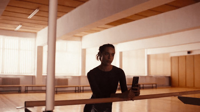 a woman holding a cell phone in an empty room