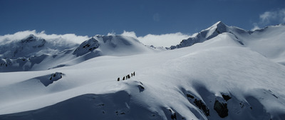 a group of people standing on top of a snow covered mountain