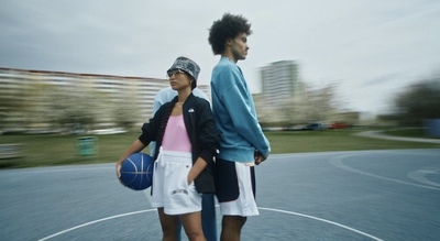 a couple of young men standing on top of a basketball court