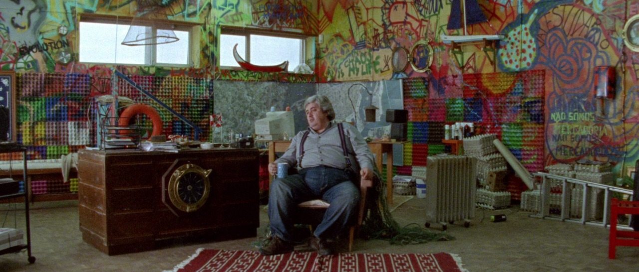 a man sitting on a chair in a room covered in graffiti