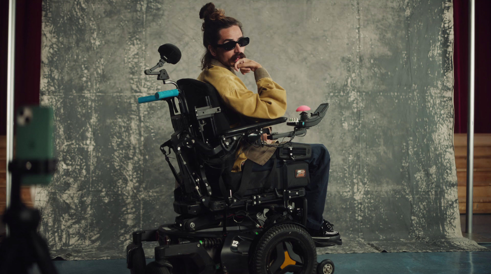 a man sitting in a wheelchair in front of a wall