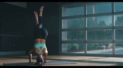 a woman doing a handstand on a yoga mat