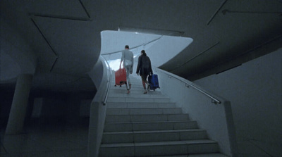 two people walking down a stairway in a dark room