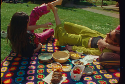 a couple of women sitting on top of a blanket