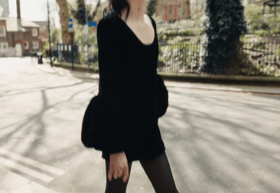 a woman walking down a street while talking on a cell phone