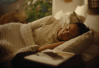 a woman laying in bed with a book