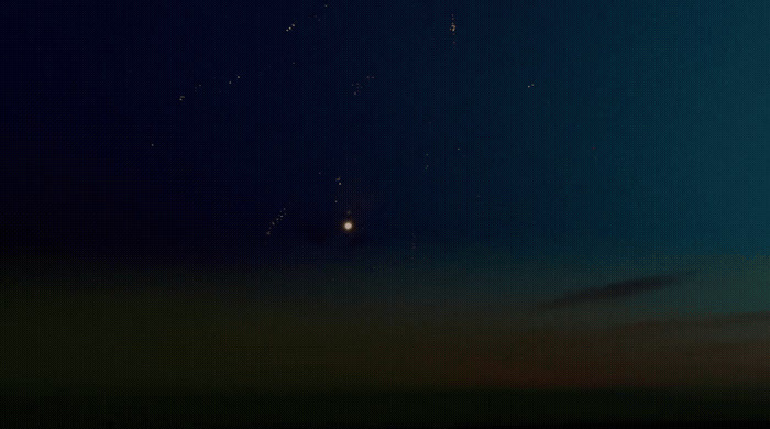 a group of people flying kites in the night sky