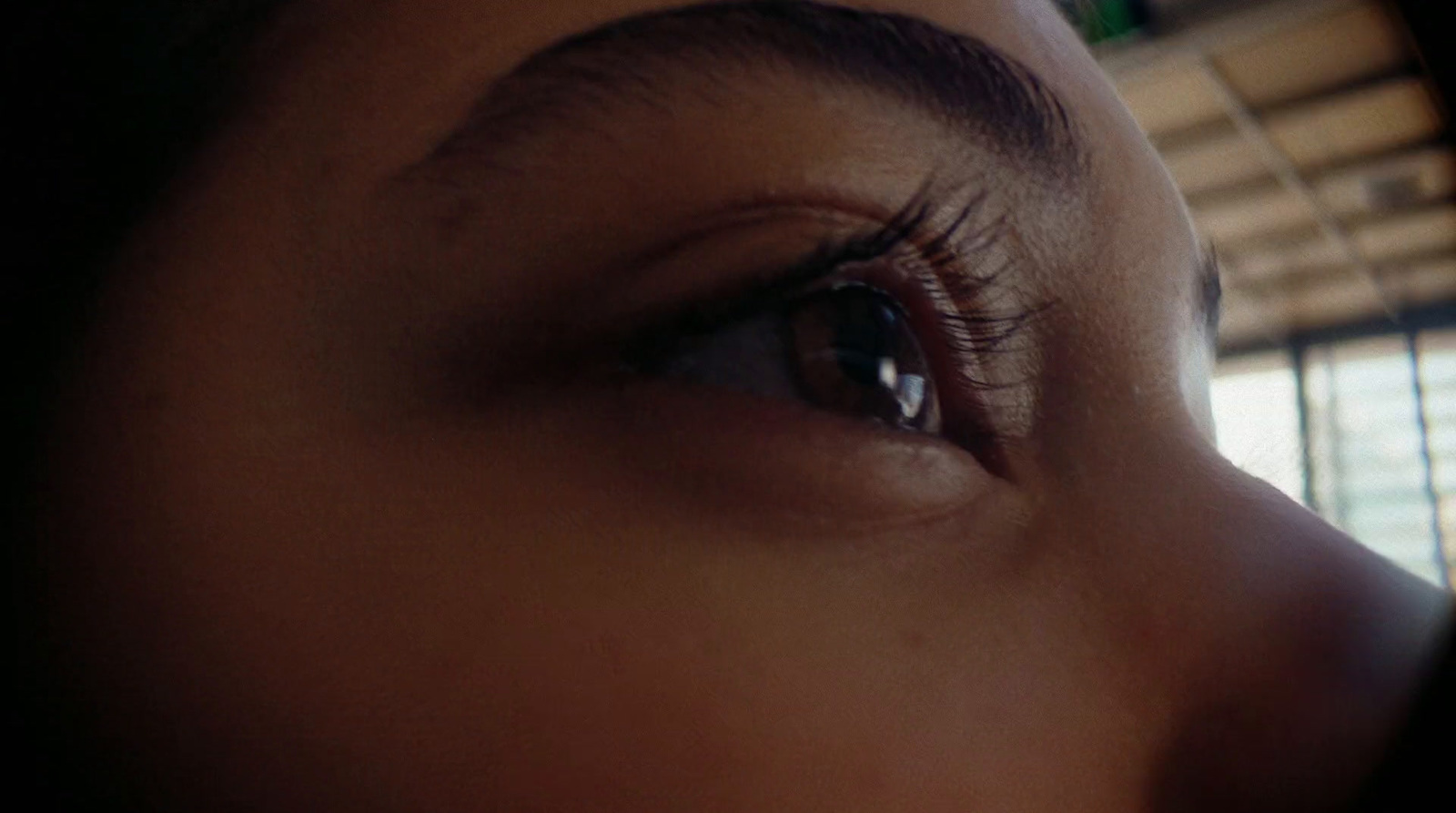 a close up of a person's eye with a window in the background