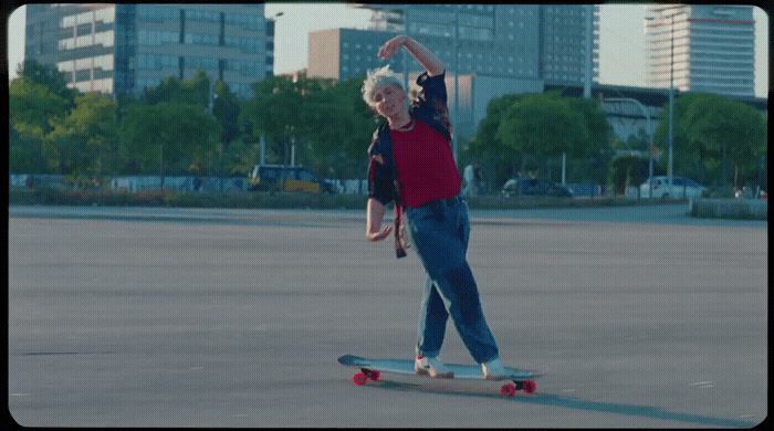 a man riding a skateboard across a parking lot