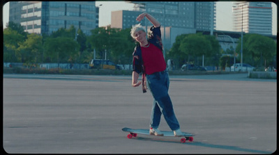 a man riding a skateboard across a parking lot