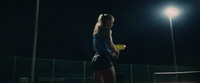 a woman holding a tennis racquet on a tennis court