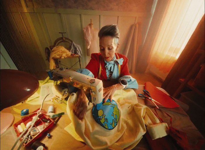 a woman in a red shirt is sewing a globe