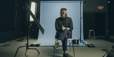 a man sitting on a chair in front of a camera