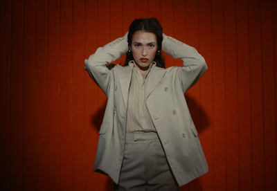 a woman standing in front of a red wall