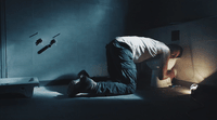 a man kneeling on the floor in a dark room