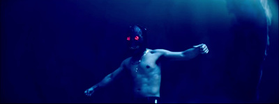 a shirtless man with red eyes and a mask on