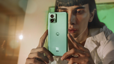 a woman is holding a green phone up to her face